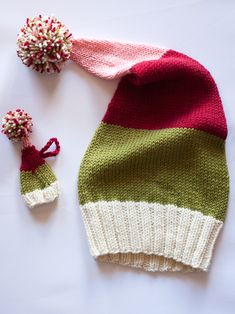 a knitted hat and two pom poms