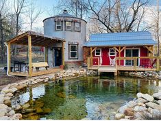 a house with a pond in front of it and a deck on the other side