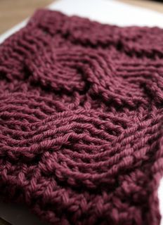 a red knitted dishcloth sitting on top of a wooden table