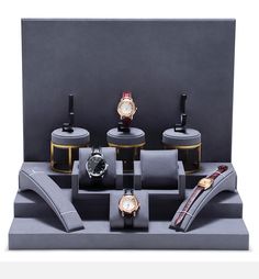 a display case with three watches and two other items in it, including one watch