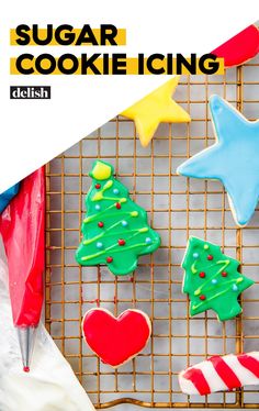 cookies decorated with icing and decorations on a cooling rack next to candy canes