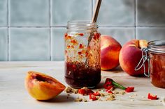 a jar filled with food sitting on top of a table next to sliced peaches