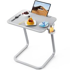 a laptop computer sitting on top of a table with food and drinks in front of it