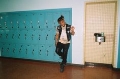 a young man standing in front of lockers