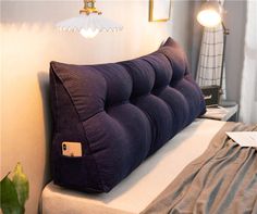 a purple pillow sitting on top of a white bed