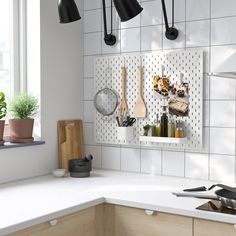 a kitchen counter with utensils hanging on the wall