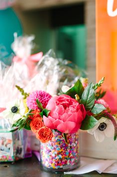 a vase filled with flowers and sprinkles on top of a table