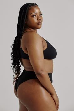 a woman in a black swimsuit posing for the camera