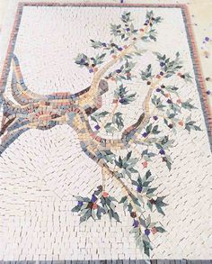 a mosaic tile floor with an animal on it's back and leaves in the middle