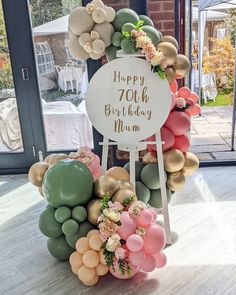 a birthday cake made out of balloons and flowers with a sign that says happy 20th birthday mum