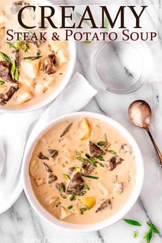 two bowls of creamy steak and potato soup on a marble counter top with spoons