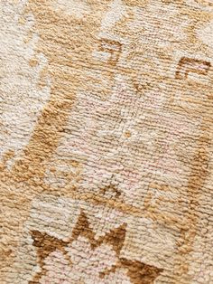 an old rug is shown with faded colors and designs on it's surface, including the face of a cat