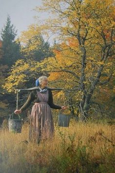 a woman standing in the middle of a field