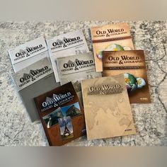 six old world cookbooks sitting on top of a granite countertop in front of a marble wall