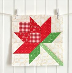 a red and green star quilt hanging on a wall