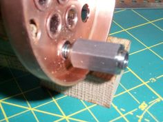 a close up of a machine wheel with holes in it on a cutting board next to scissors