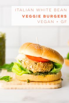 an italian white bean veggie burger with lettuce and tomato on a cutting board