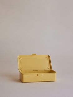 a yellow suitcase sitting on top of a white table