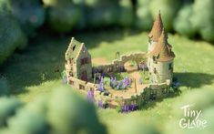 a model of a castle with purple flowers in the foreground and trees in the background