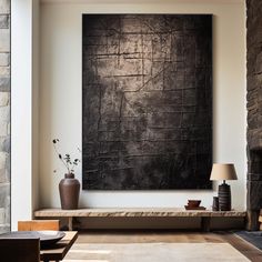 a living room with a large black painting on the wall and a table in front of it