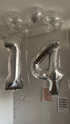 balloons and streamers are hanging from the ceiling in front of a number four balloon