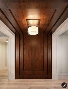 an empty room with wood paneling and lights on the ceiling is pictured in this image