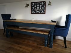 a wooden table with two blue chairs next to it