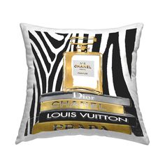 a black and white pillow with a bottle of chanel perfume on the front in gold foil