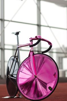 a pink bicycle is parked in front of a building