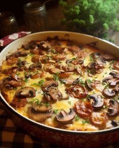 a casserole dish with mushrooms and cheese in it on a checkered tablecloth