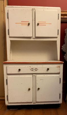 an old white cabinet with two doors and drawers