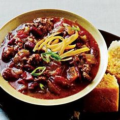 a bowl of chili and bread on a plate