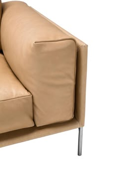 a tan leather couch sitting on top of a white floor