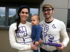 a man and woman holding a baby wearing matching shirts