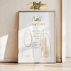 a white poster with gold foil on it in front of a wall that says nail anatomy