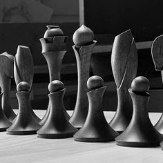 chess pieces lined up on a table in black and white