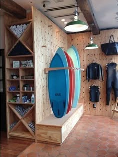 there is a surfboard on display in the shop with other items hanging from the wall