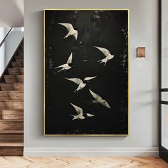 birds flying in the air on a black and white wall above a wooden floor with stairs