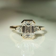 an emerald cut diamond ring with three side stones