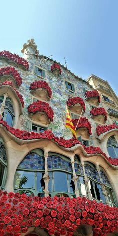 an elaborate building with red flowers on the windows