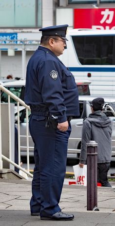 a police officer is standing on the sidewalk