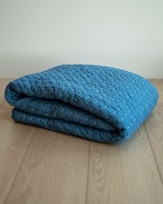 two blue blankets sitting on top of a wooden floor