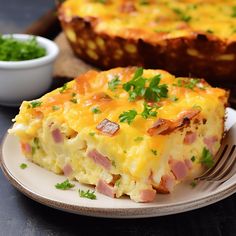 a slice of ham and cheese quiche on a plate next to a bowl of parsley