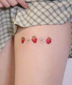 a woman's thigh with three strawberries on it