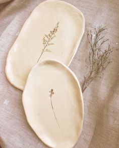 two plates with flowers on them sitting on a bed