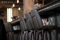 a row of chairs sitting next to each other in front of a bar