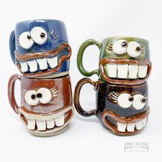 two ceramic mugs with monster faces on them