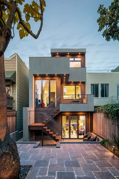 a modern house with stairs leading up to the second floor and an open patio area