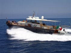 a boat with people riding on it in the middle of the ocean near another boat