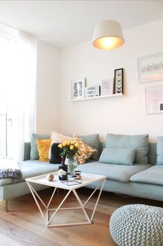 a living room filled with furniture next to a large window and a wooden floor covered in hard wood floors